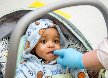 baby, adult hand touching teeth
