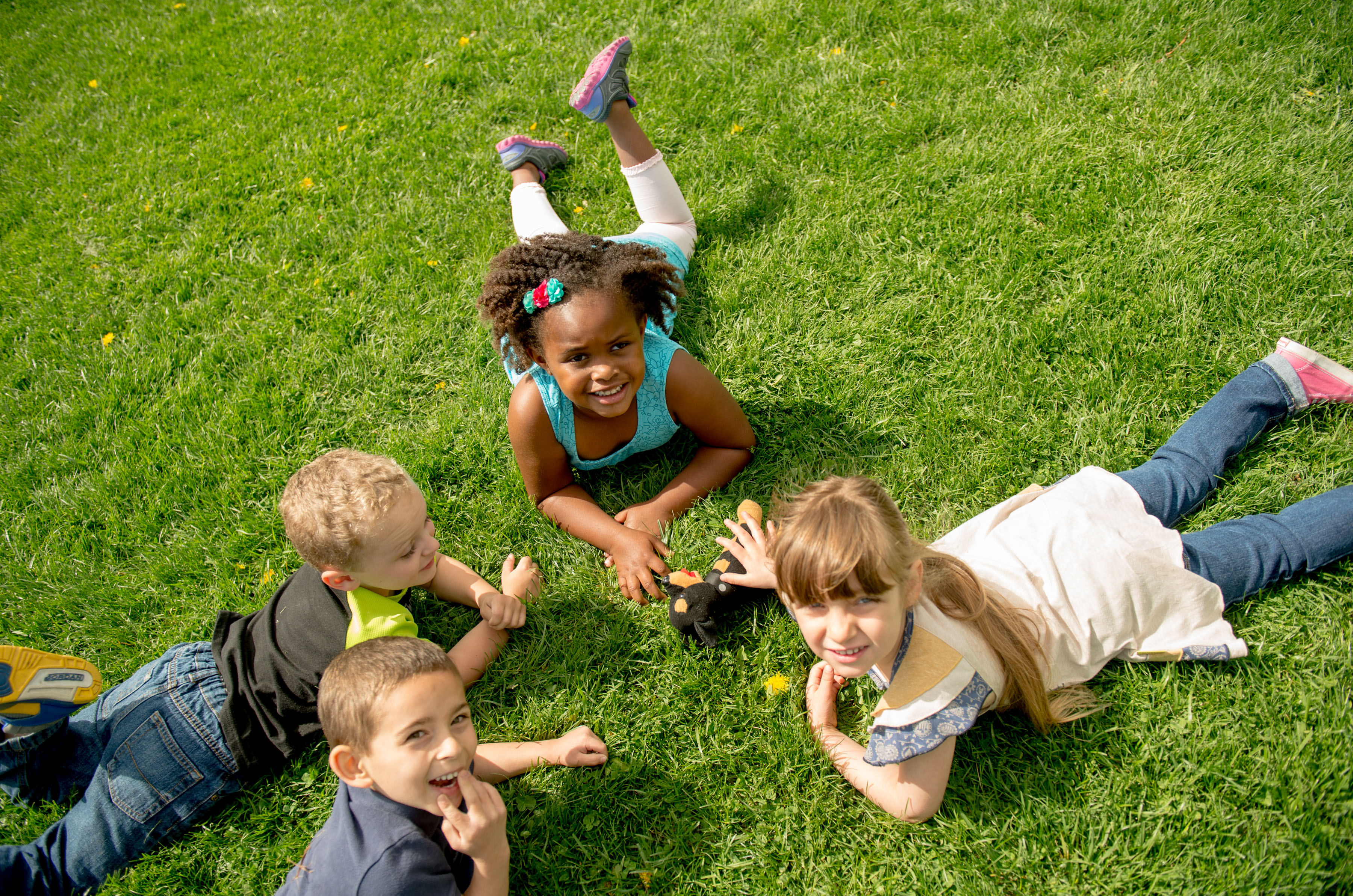 circle of children lying on the grass