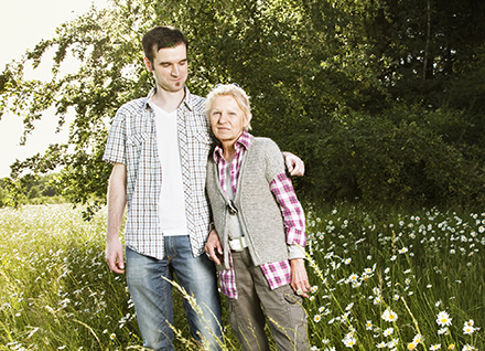 Young man and older woman standing in field of daises. Young man and older woman standing in field of daises.