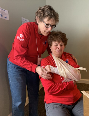 person helping someone with a bandaged arm person helping someone with a bandaged arm