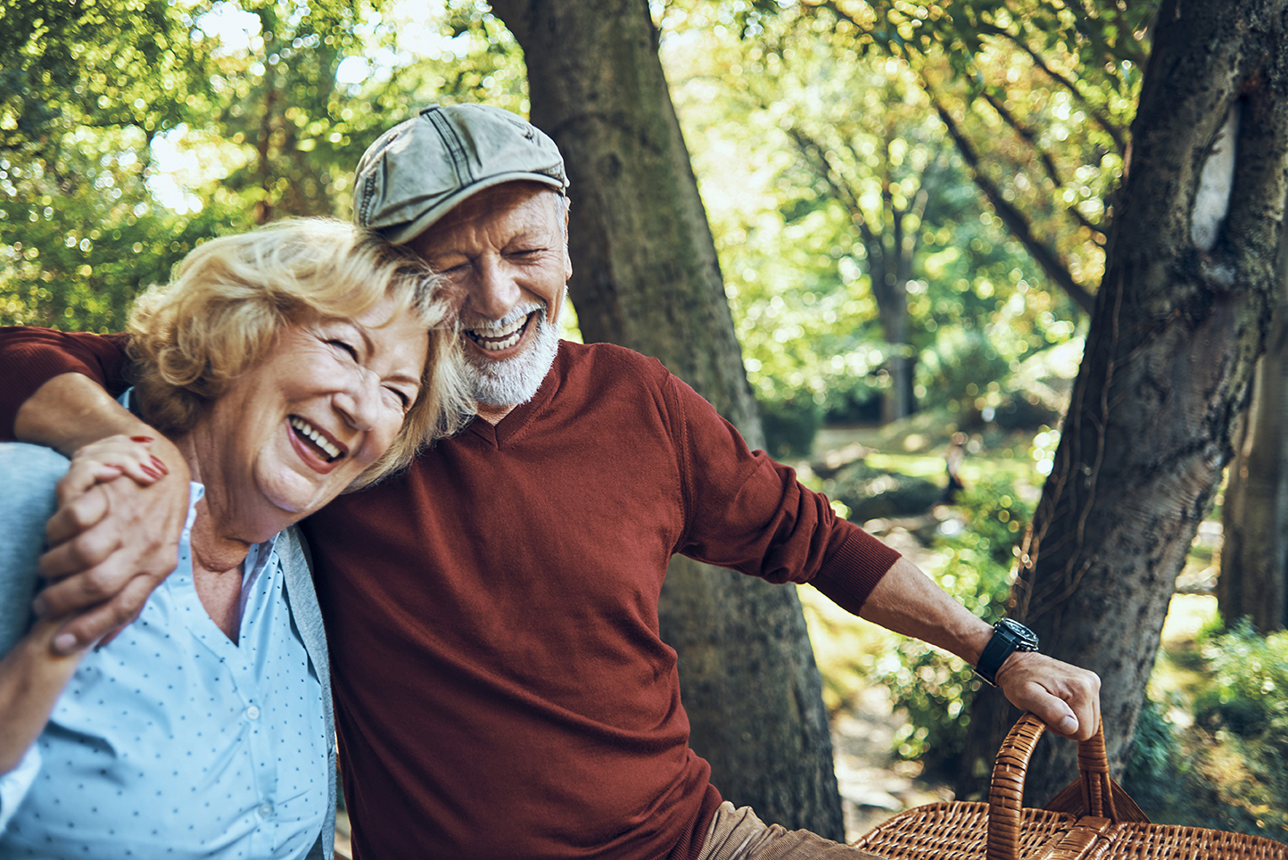 Older man and woman smiling with picnic basket