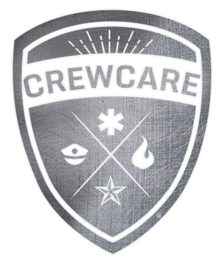 a metal badge reading Crewcare with icons of fire, military stars, a police officer's hat, and the star of life on it