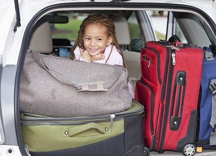 girl and luggage in car