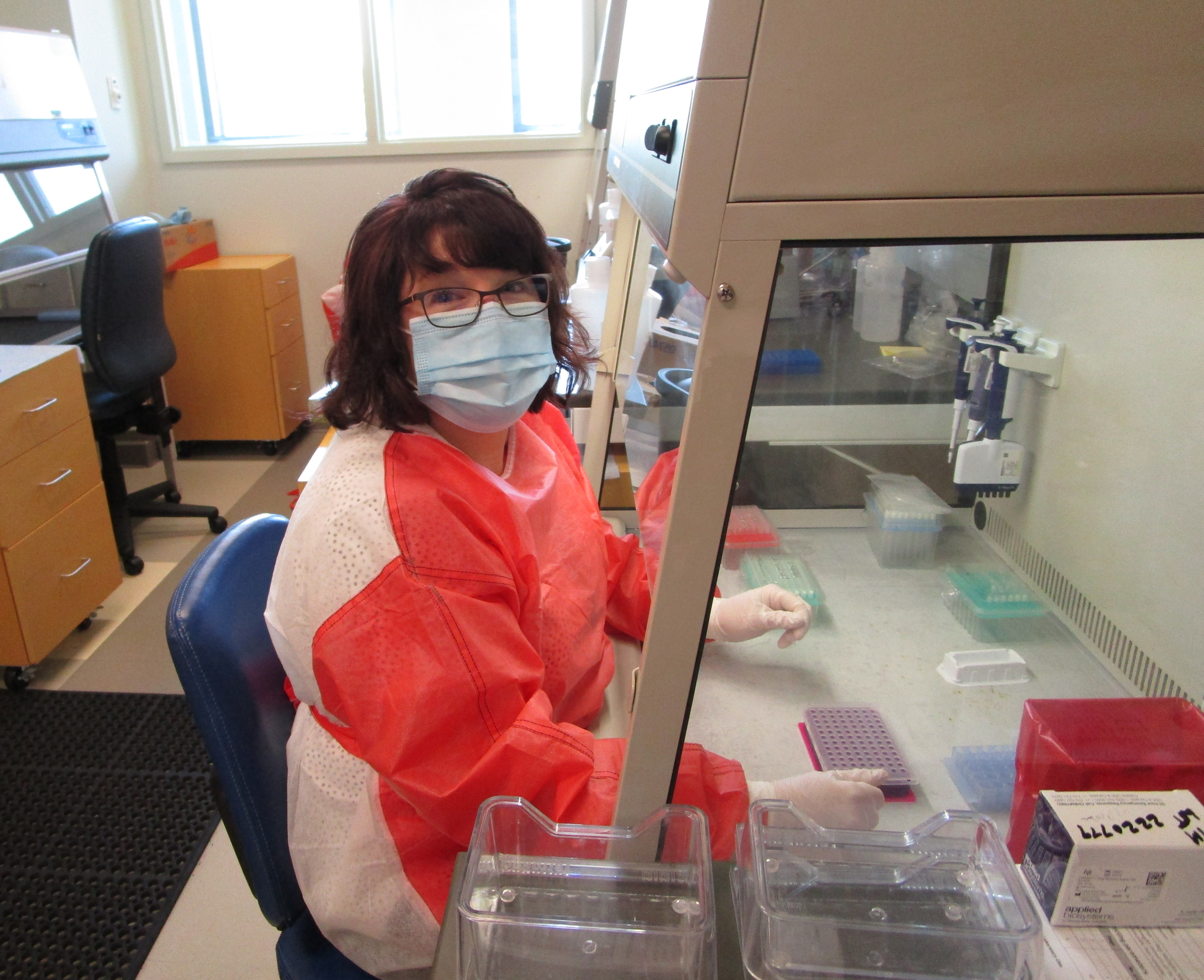 lab worker with protective clothing mask at lab table