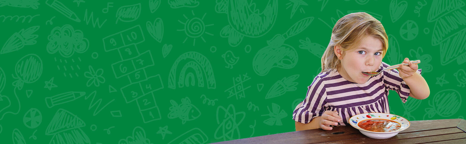 Child eating soup with a green background