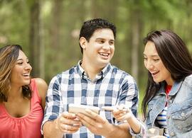 three young adults looking at phone