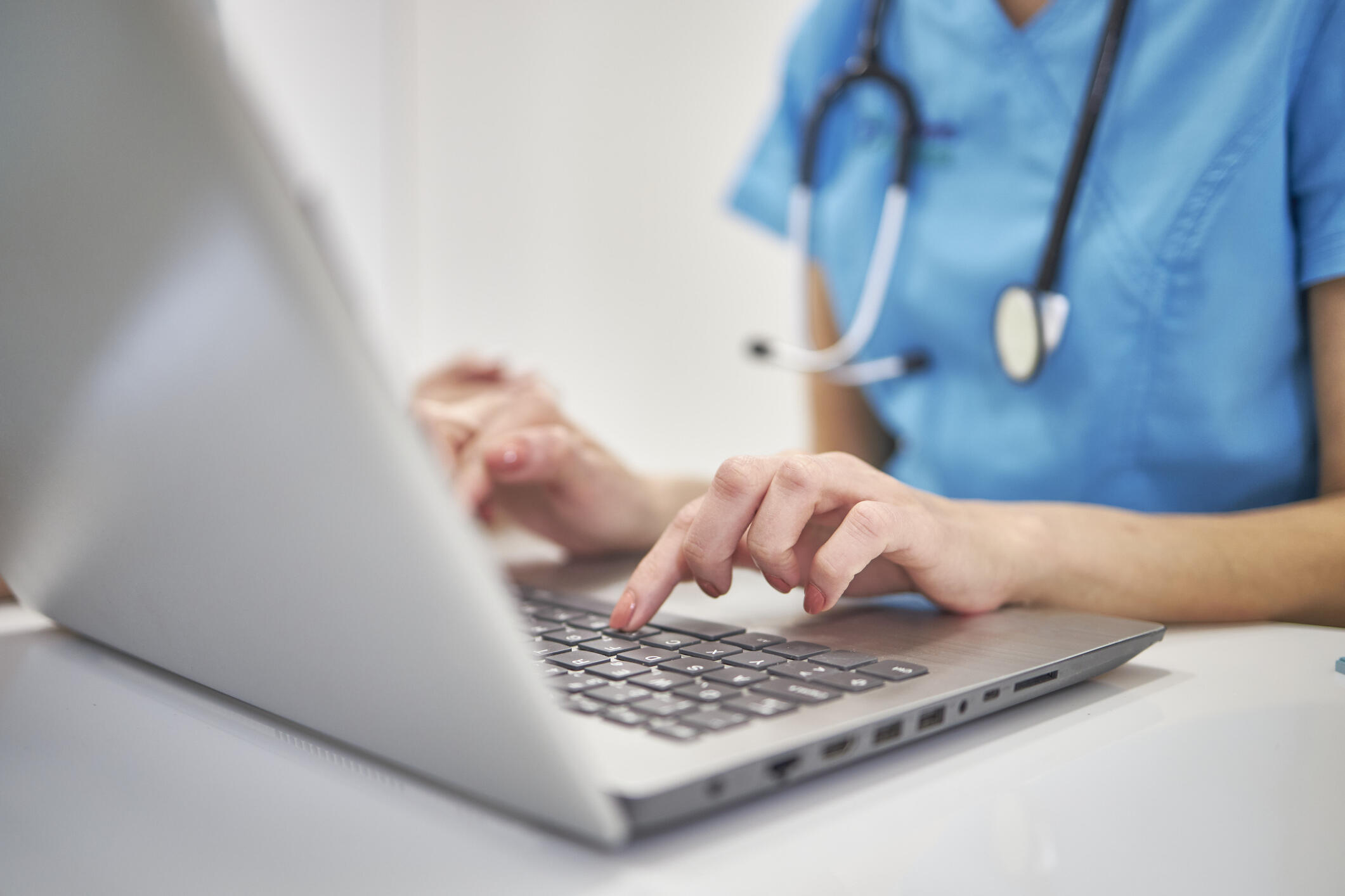 nurse or healthcare worker typing on a laptop