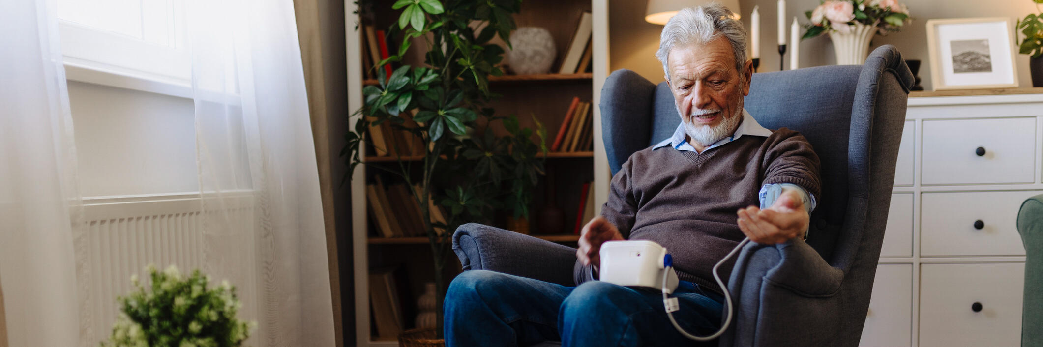 Older man checking his blood pressure at home. 