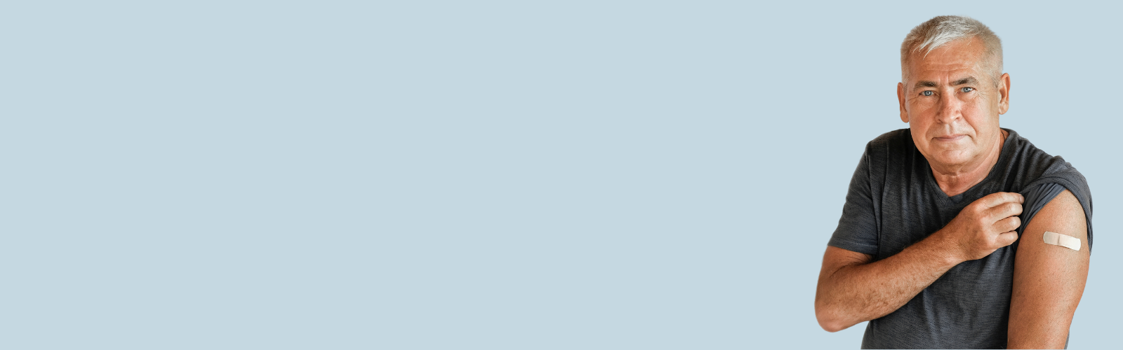 man with gray hair pulling up sleeve to show bandage