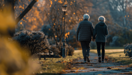 Two older adults walking away on a recreation path during fall.