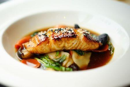 cooked fish in a bowl with vegetables and broth