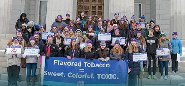 teens and signs on Statehouse steps