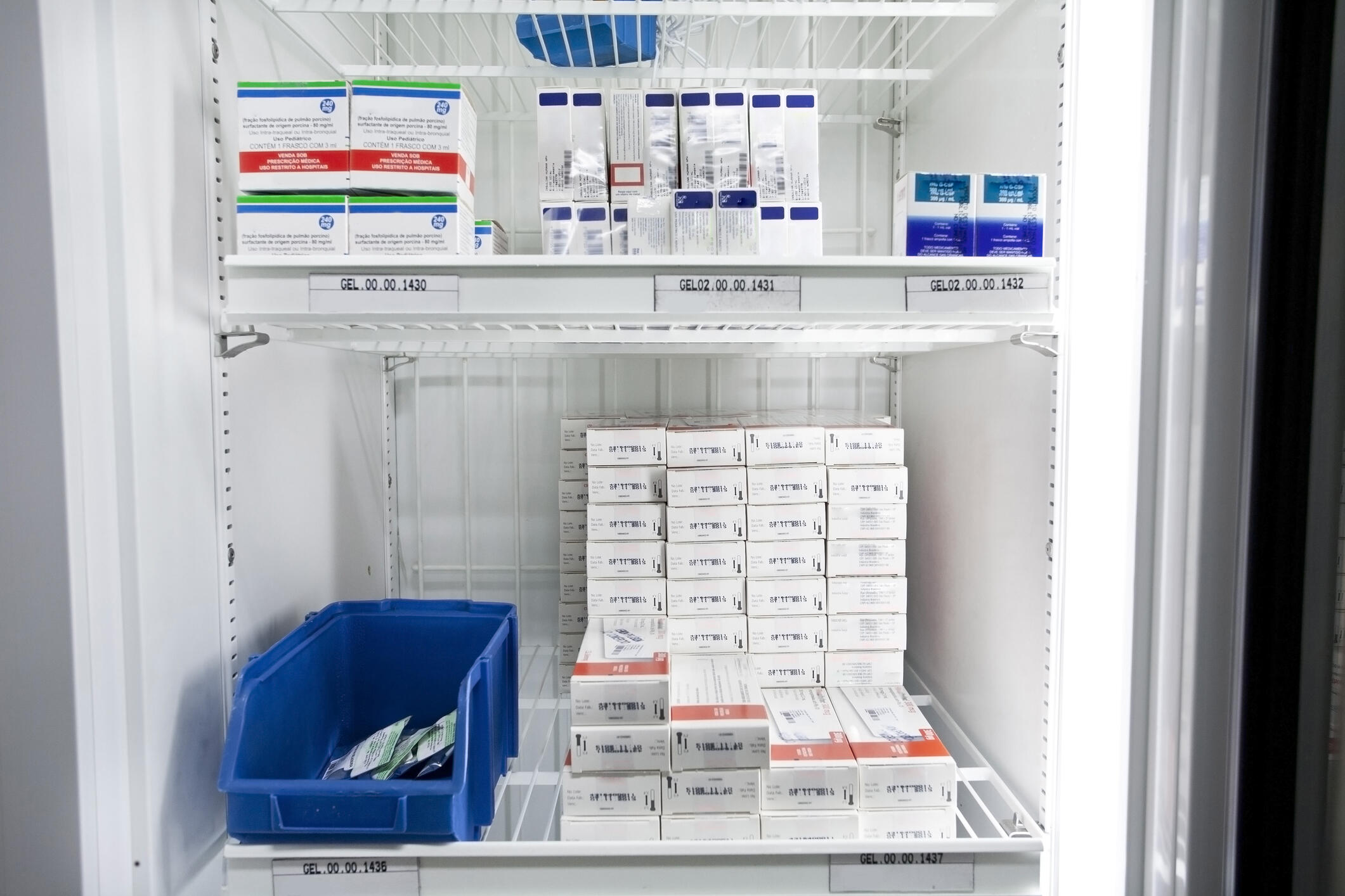 A photo of a vaccine refrigerator with stacks of vaccine boxes
