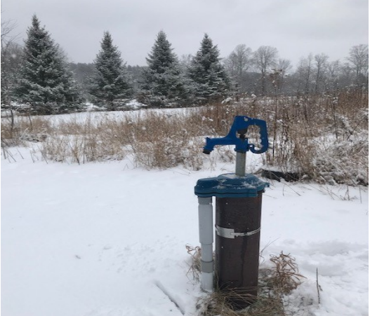 A well in a snowy yard.