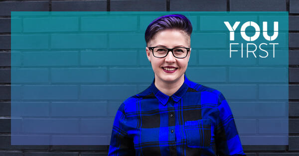 Person standing in front of brick wall, with You First logo