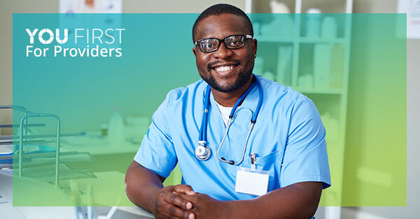 Health care provider sitting down and smiling, with You First logo