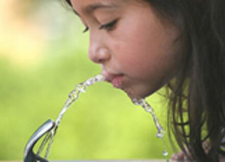 Girl drinks from water fountain