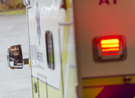 ambulance with driver seen in mirror