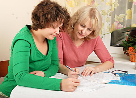 Older woman assists younger woman with important papers