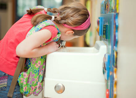 girl drinking from water fountain
