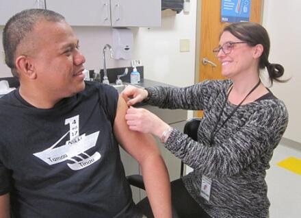 woman giving vaccination to man