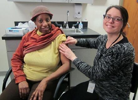 woman getting a vaccination from a nurse