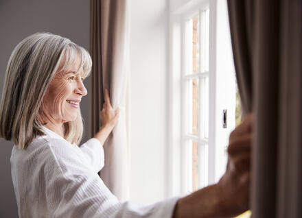 women opening window in home