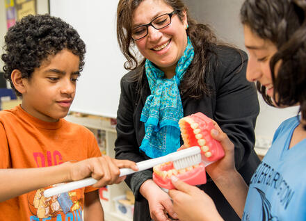 woman showing students model teeth woman showing students model teeth