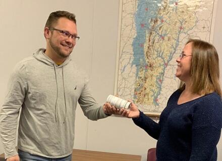 person handing town health officer a water kit
