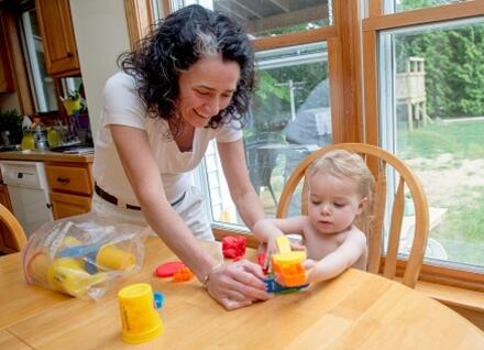 woman helping toddler with playdoh