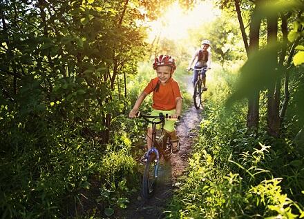 two children biking in woods two children biking in woods