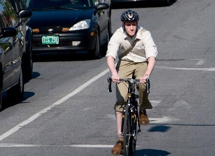 man biking near cars