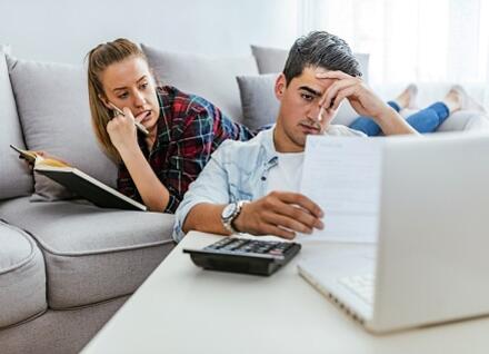 young couple at computer look concerned