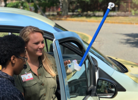 two people attaching heat monitoring equipment on a car two people attaching heat monitoring equipment on a car