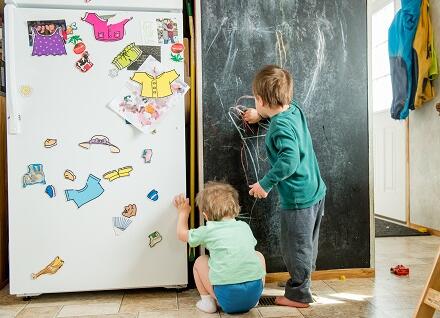 two children drawing on blackboard