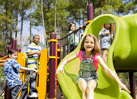 Happy young children on a playground on a sunny day