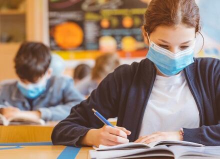 student at desk looking at book