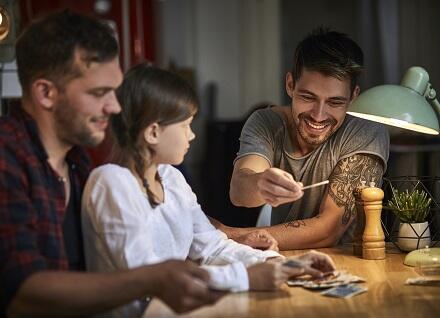 two men and girl playing cards
