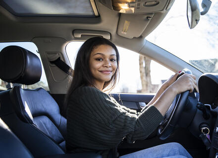 Portrait of teenage girl in her first car