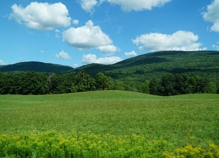 mountains and field with clouds in sky mountains and field with clouds in sky