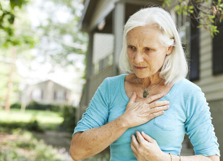 woman holding her chest woman holding her chest