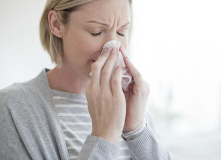 Woman blowing her nose with tissue