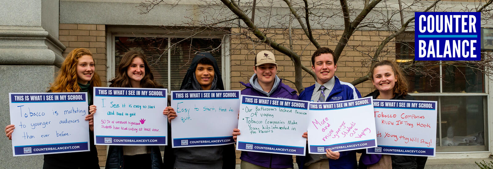 Teens holding signs about hopes for their schools