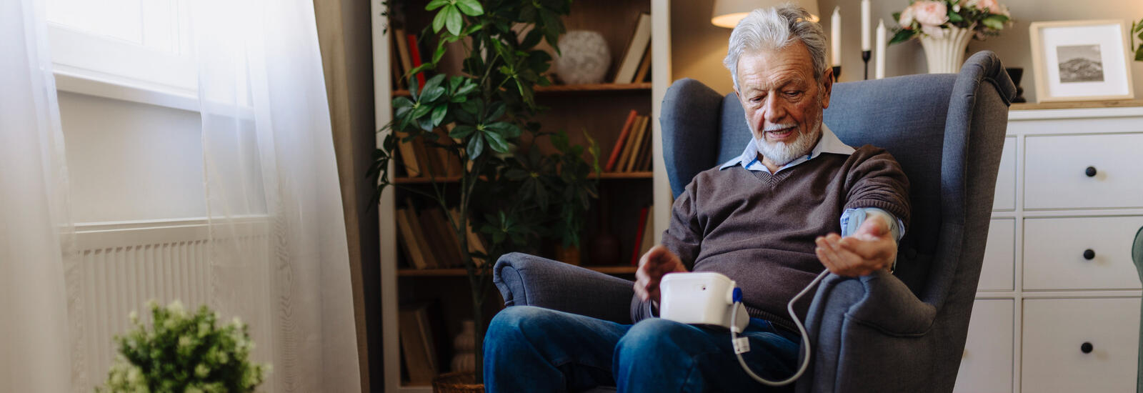 Older man checking his blood pressure at home. 