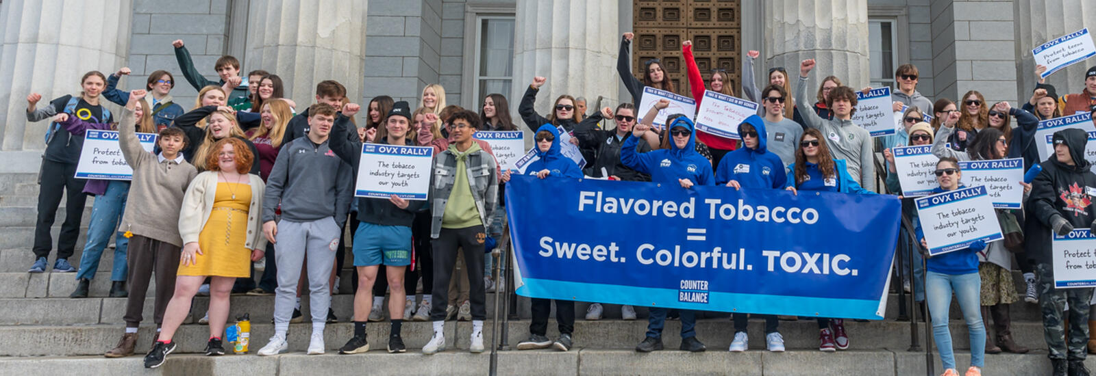 Group of people on the Statehouse steps for OVX rally holding signs about tobacco.
