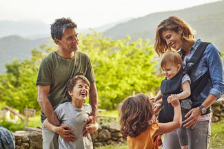 Mother, father, two young children and a baby outdoors