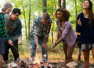 Young adults around a campfire