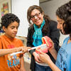 woman showing students model teeth