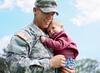 man in uniform holding baby