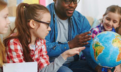 teacher with students and globe